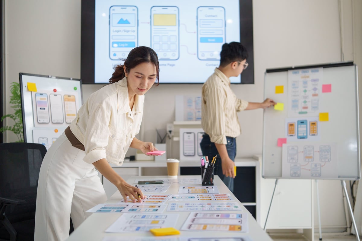 UX designer writing notes on sticky paper while planning a website interface